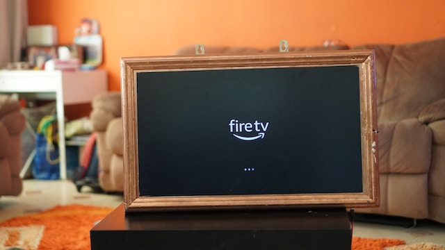Person setting up IPTV on Firestick with a TV in the background